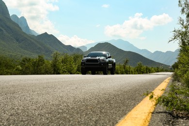 Photo of Black car on road near beautiful mountains outdoors