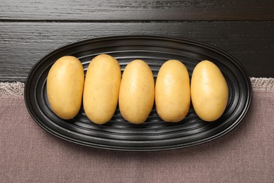 Fresh raw potatoes on wooden table, top view