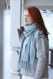 Photo of Beautiful young woman in wooden gazebo on snowy day outdoors. Winter vacation