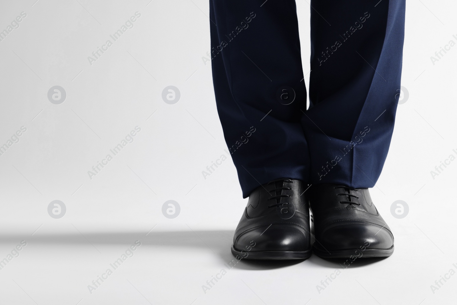 Photo of Businessman in leather shoes on white background, closeup