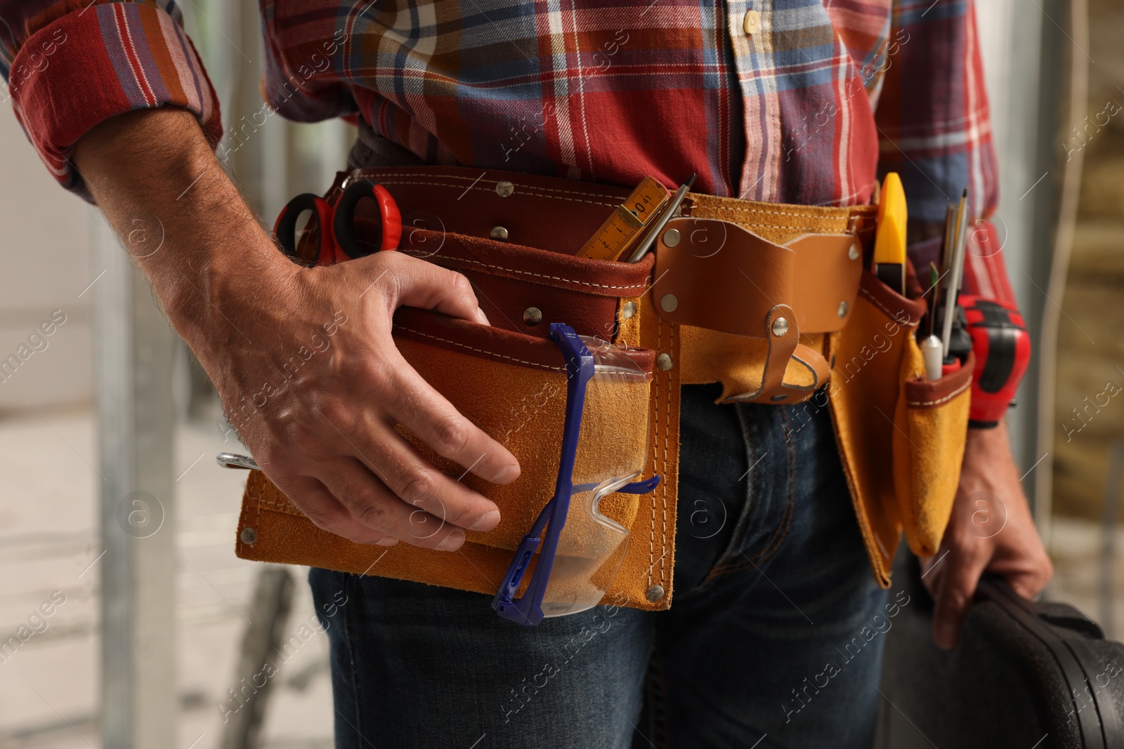 Photo of Professional builder with tool belt indoors, closeup