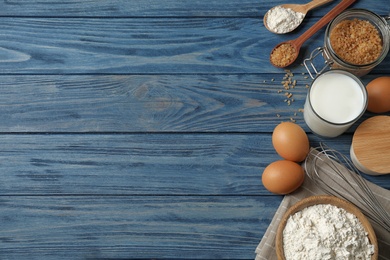 Photo of Flat lay composition with fresh ingredients for delicious homemade cake on blue wooden table. Space for text