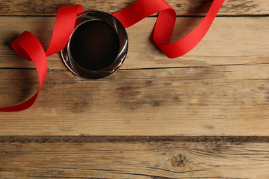 Photo of Bronze medal with red ribbon on wooden background, flat lay. Space for design