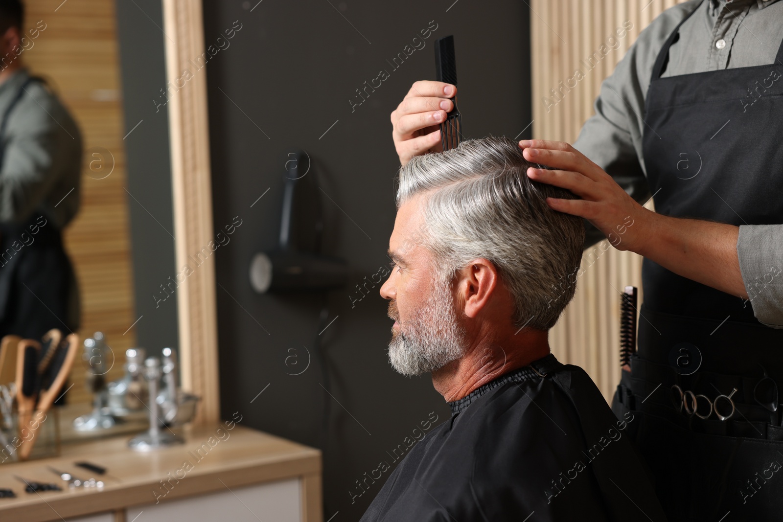 Photo of Hair styling. Professional hairdresser working with client in barbershop, closeup