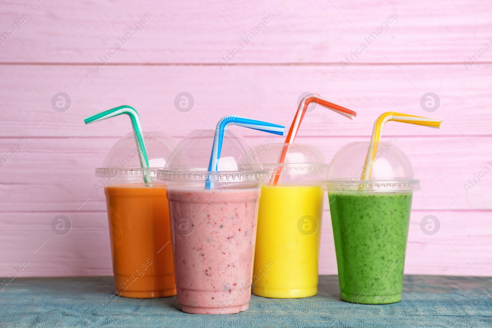 Photo of Plastic cups with delicious detox smoothies on table