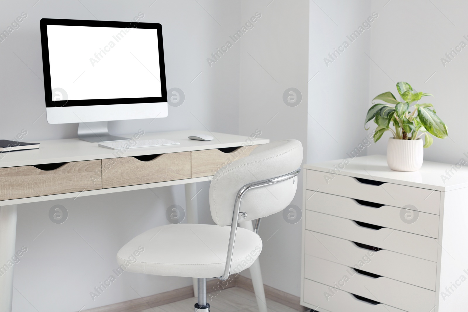 Photo of Stylish office interior with comfortable chair, desk and computer