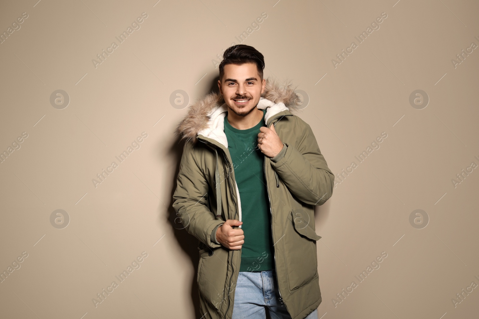 Photo of Young man wearing warm clothes on color background. Ready for winter vacation