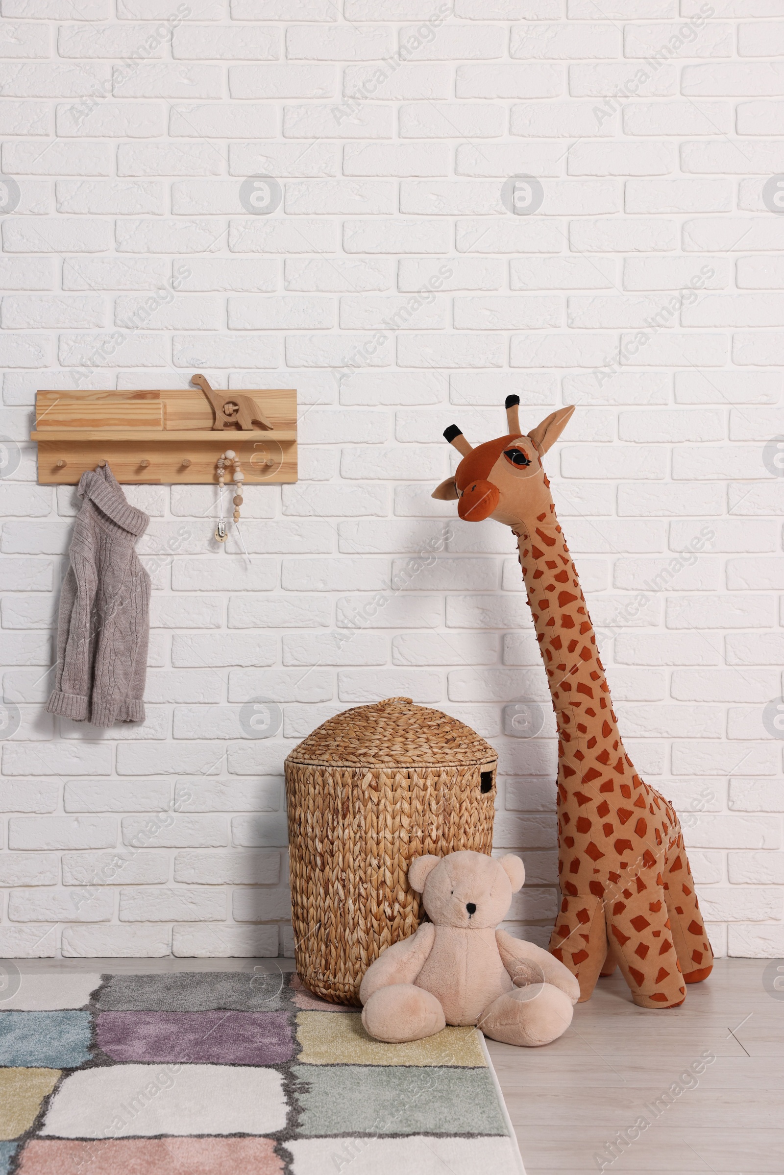 Photo of Beautiful children's room with white brick wall and toys. Interior design