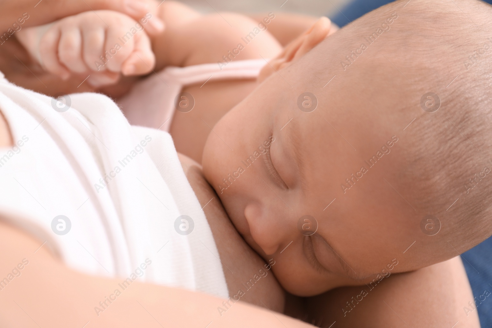 Photo of Young woman breastfeeding her little baby at home, above view