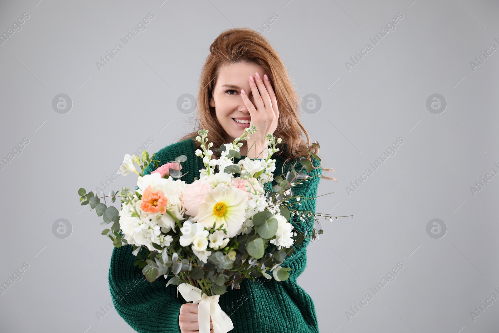 Photo of Beautiful woman with bouquet of flowers on grey background