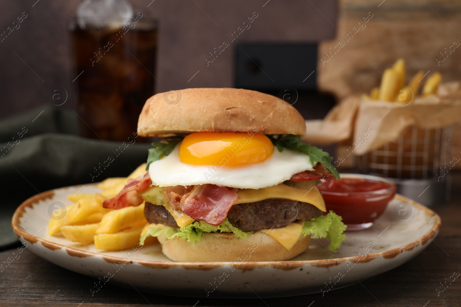 Photo of Delicious burger with fried egg and french fries served on wooden table, closeup