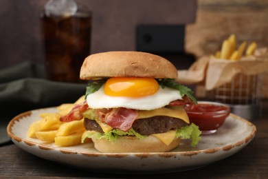 Photo of Delicious burger with fried egg and french fries served on wooden table, closeup