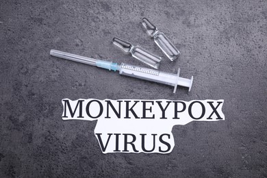 Photo of Words Monkeypox Virus, syringe and vials on grey table, flat lay
