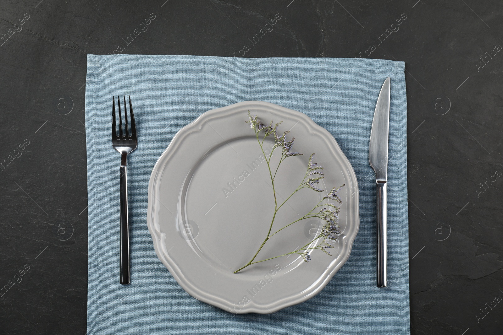 Photo of Stylish setting with elegant cutlery on grey textured table, top view