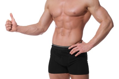 Photo of Young man is stylish black underwear showing thumb up on white background, closeup