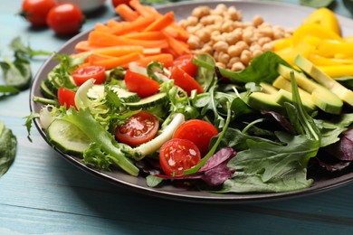 Photo of Balanced diet and vegetarian foods. Plate with different delicious products on light blue wooden table, closeup