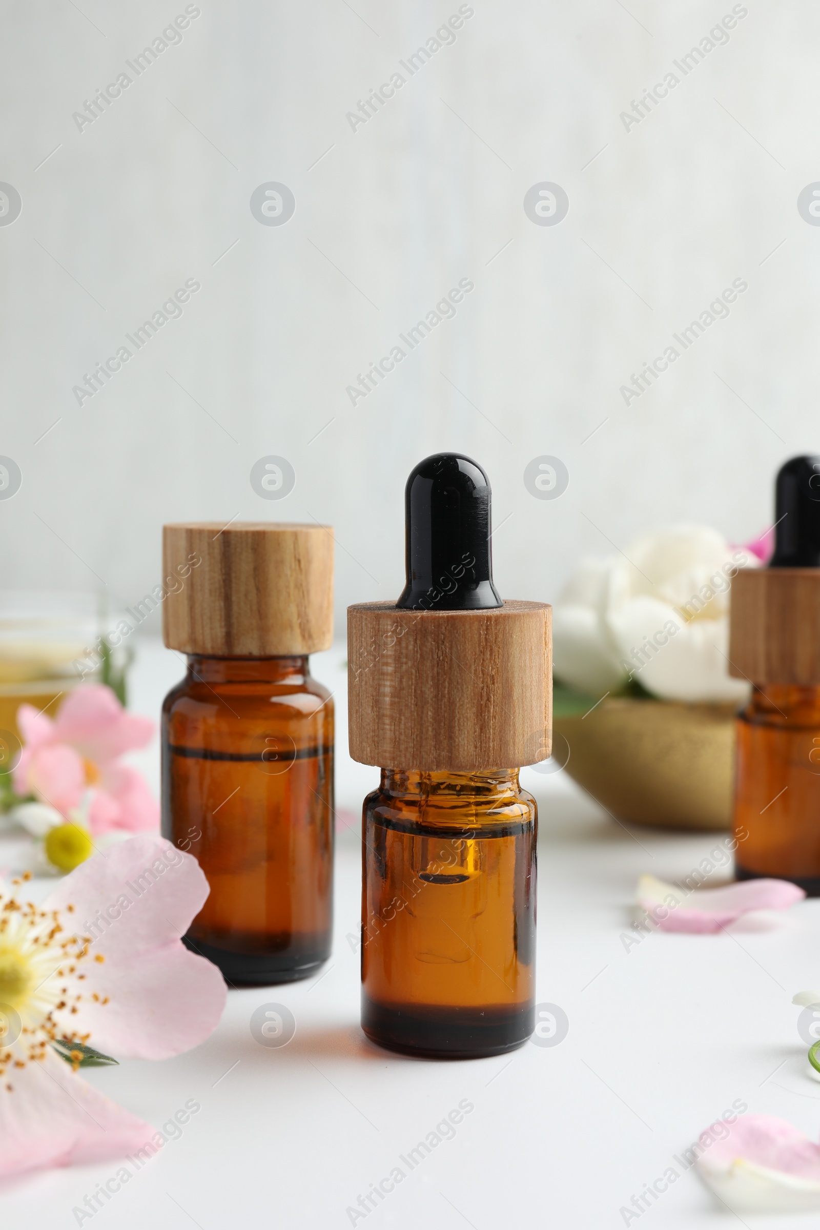 Photo of Aromatherapy. Essential oils and flowers on white table