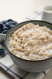 Photo of Tasty oatmeal porridge served on table, closeup