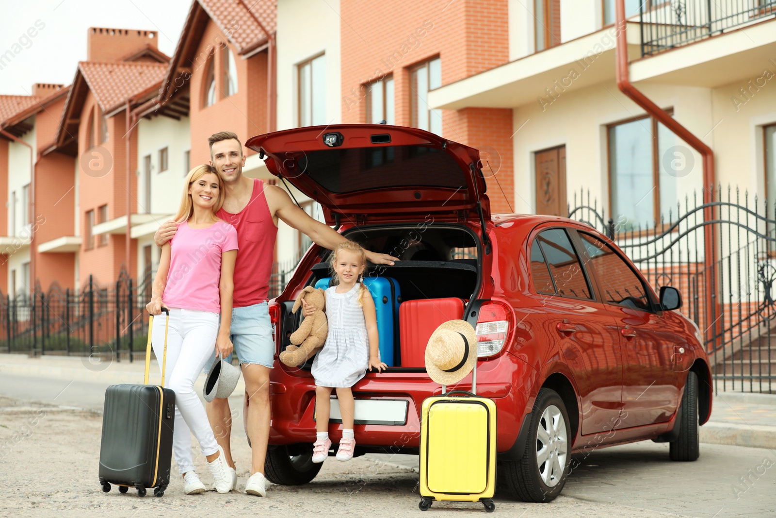 Photo of Happy family near car trunk with suitcases outdoors