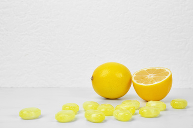 Photo of Fresh lemon and tasty drops on white table