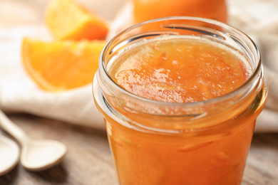 Homemade delicious orange jam on table, closeup view