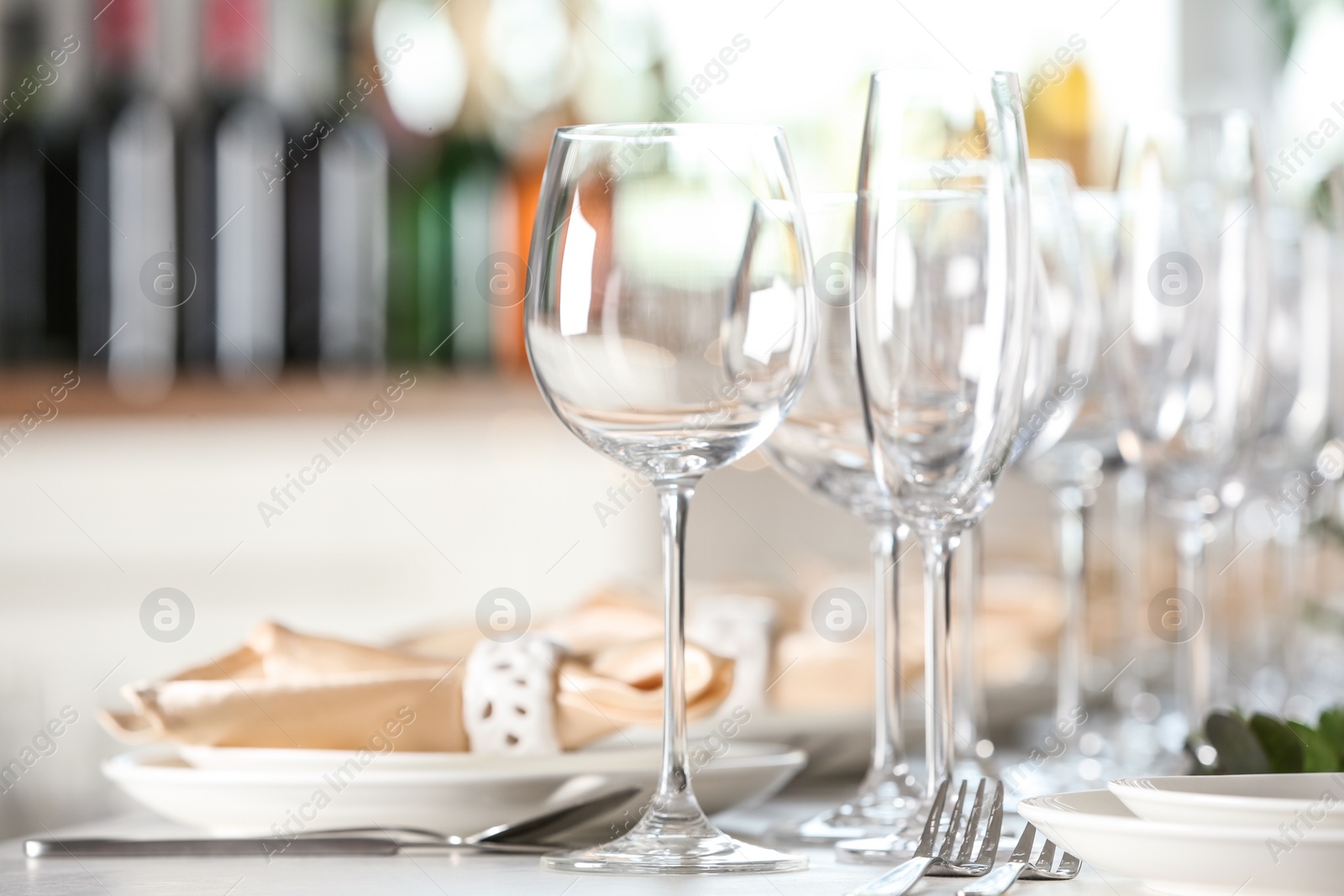 Photo of Table setting with empty glasses, plates and cutlery indoors