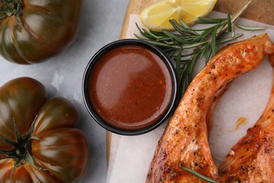 Fresh marinade, cooked fish and other products on grey table, flat lay