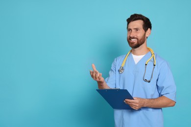 Photo of Happy doctor with stethoscope and clipboard on light blue background. Space for text