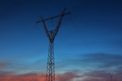 Photo of Telephone pole with cables at sunset outdoors