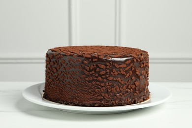 Photo of Delicious chocolate truffle cake on white marble table