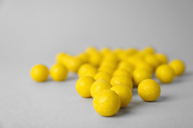 Delicious lemon chewing gums on light grey background, closeup