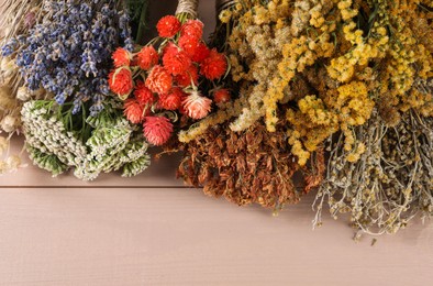 Photo of Different medicinal herbs on wooden table, above view. Space for text