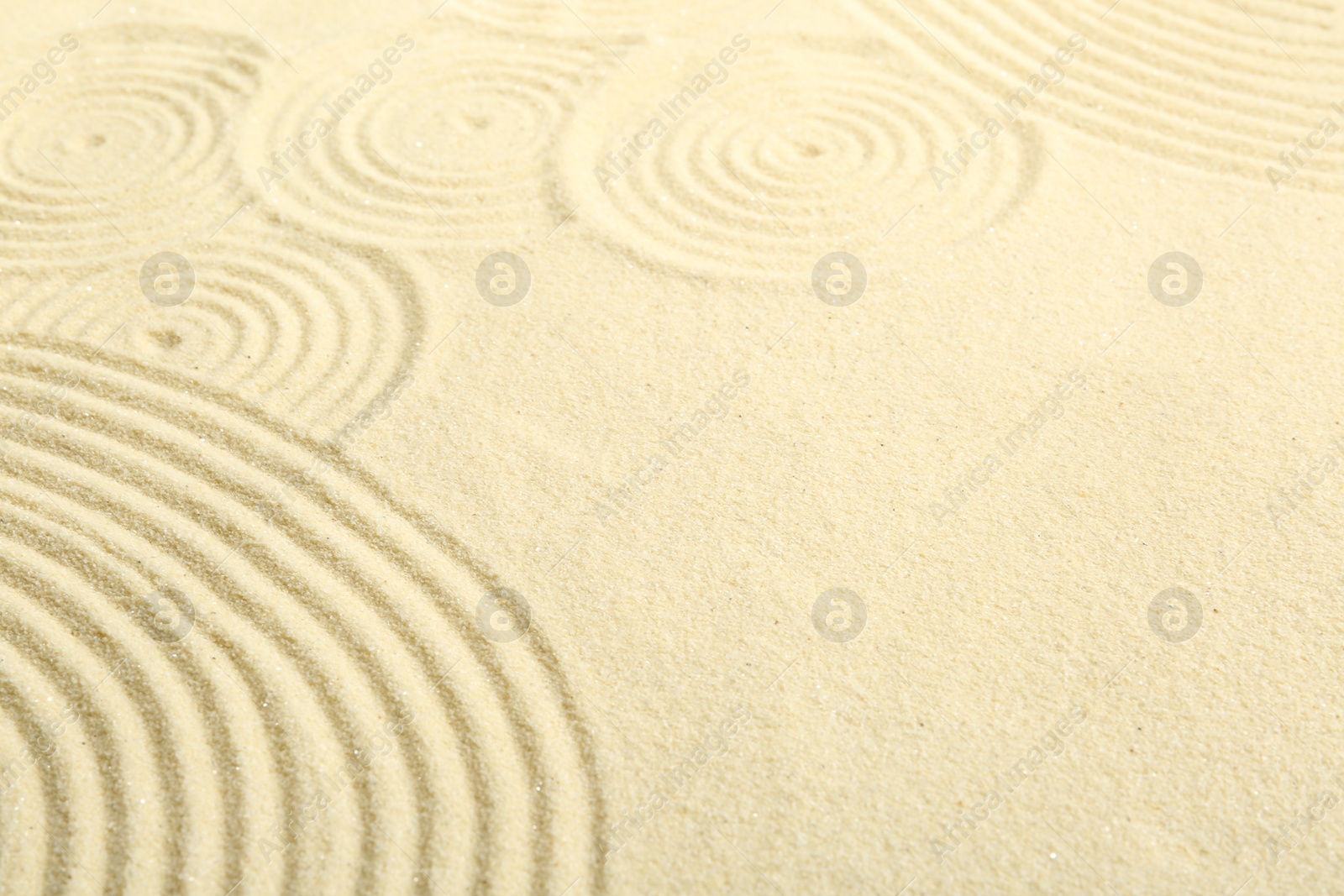 Photo of Zen rock garden. Circle patterns on beige sand