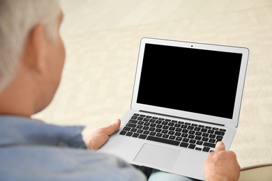 Photo of Man using video chat on laptop at home, closeup. Space for text