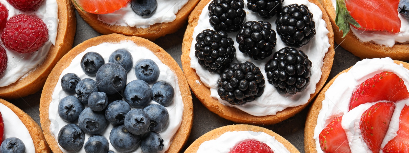 Image of Delicious tartlets with fresh berries, top view. Banner design