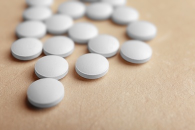 White pills on light background