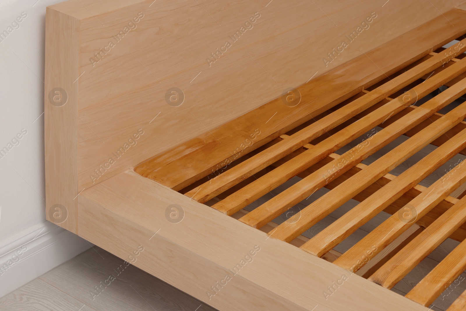 Photo of Closeup view of new wooden bed frame indoors