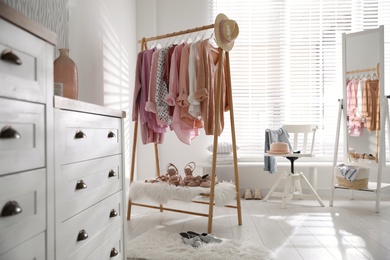 Rack with stylish women's clothes indoors. Interior design