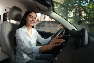 Photo of Young woman using navigation system while driving car