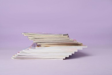 Group of stacked magazines on violet background