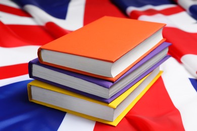 Photo of Learning foreign language. Different books on flag of United Kingdom