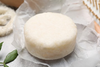 Photo of Solid shampoo bar on light grey table, closeup