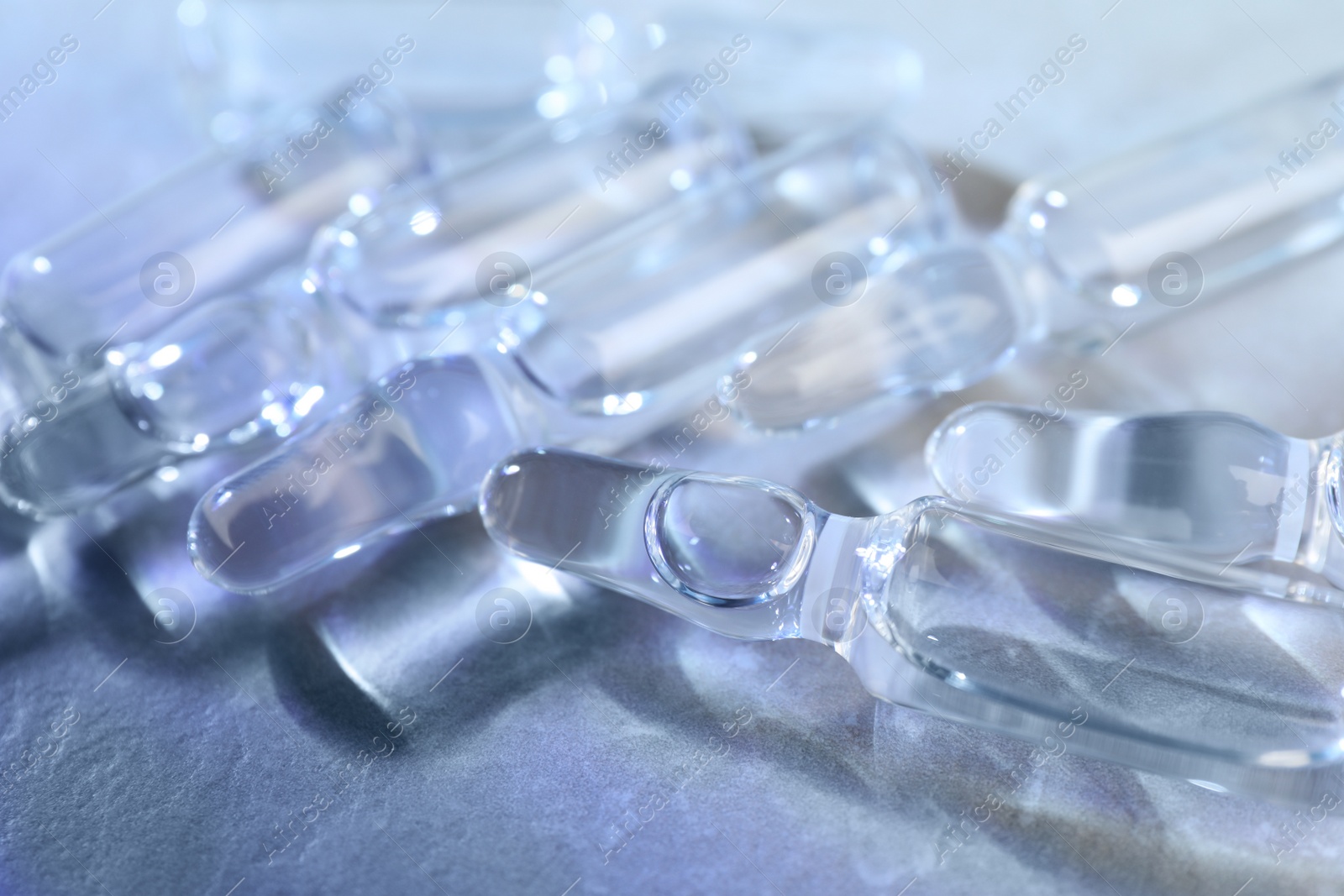 Photo of Pharmaceutical ampoules with medication on grey table, closeup