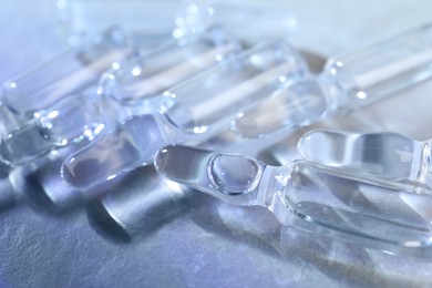 Photo of Pharmaceutical ampoules with medication on grey table, closeup