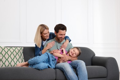 Photo of Happy family having fun together on sofa at home