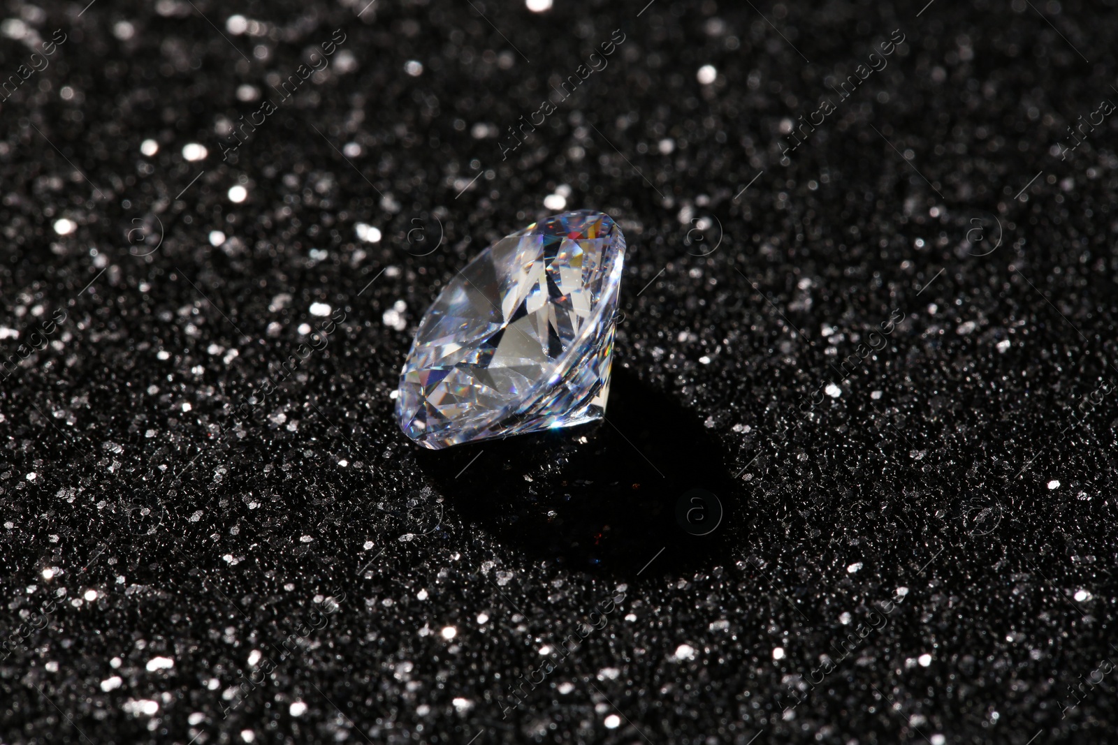 Photo of Beautiful dazzling diamond on dark shiny background