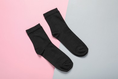 Photo of Pair of black socks on color background, flat lay