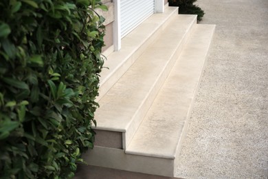 Photo of View of modern grey tile empty staircase near green plant outdoors