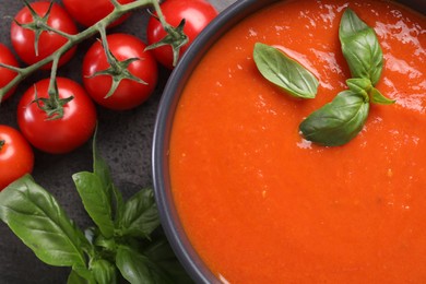 Delicious tomato cream soup in bowl and ingredients on grey table, flat lay