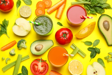 Photo of Delicious juices and fresh ingredients on yellow background, flat lay